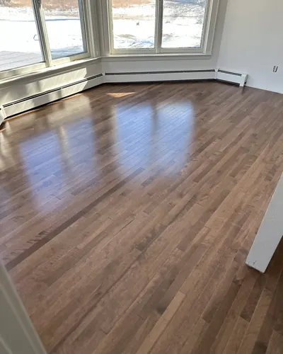 Glossy hardwood floor in a room with a bay window