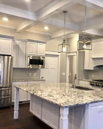 Dark hardwood floor in a white kitchen with a large island