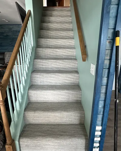Patterned carpet on a staircase with white spindles