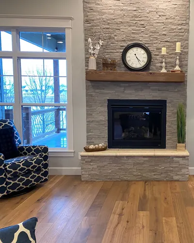 Wide-plank floor in front of a stone fireplace