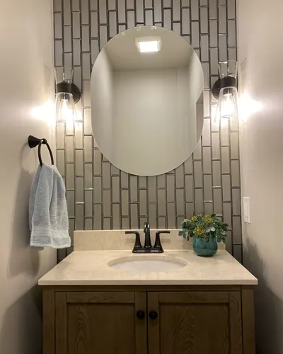 Vertical glass subway tile behind a powder room vanity